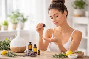 femme brune avec chignon utilisant des huiles essentielles pour aromathérapie et bien-être naturel